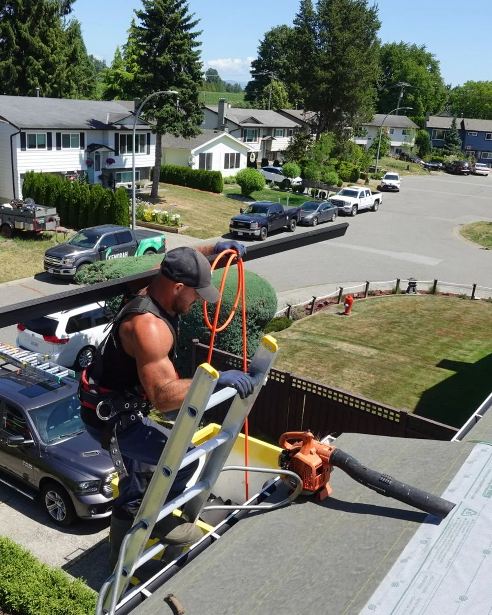 Somerville Roofing crew member carrying materials up to a roof in the Lower Mainland