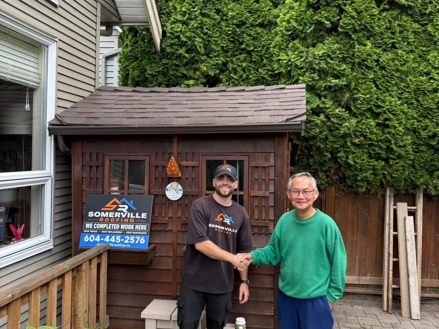 Homeowner shaking hands with the Somerville Roofing crew after a finished job